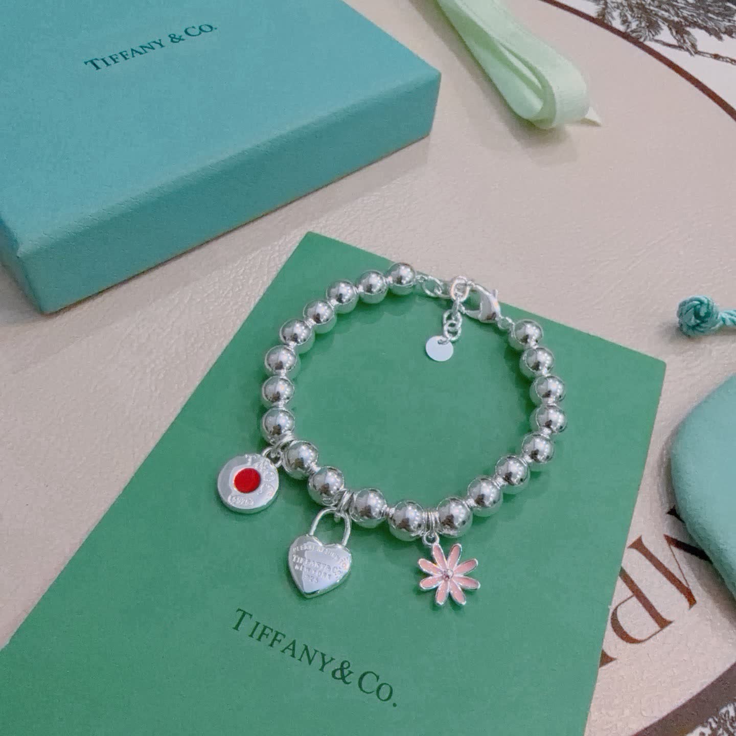 Tiffany & Co. Sterling Silver Bead Bracelet with Lock and Flower Charms